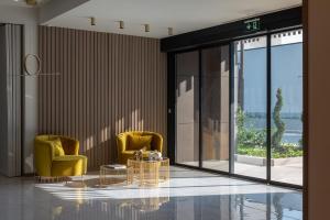 a lobby with two yellow chairs and a glass table at GRAND PATELLI in Myrina
