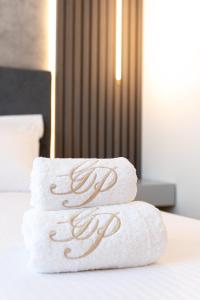 a stack of towels sitting on top of a bed at GRAND PATELLI in Myrina