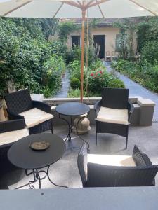 un patio con mesas, sillas y una sombrilla en Charming Apt in San Frediano, en Florencia