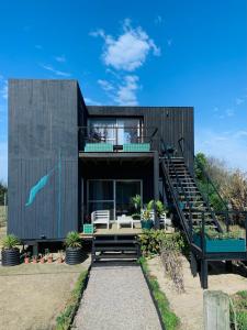 una casa negra con terraza y escalera en Sand Wood Lofts, en José Ignacio