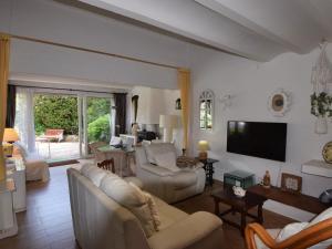 a living room with couches and a tv on the wall at Villa Cala in Santa Cristina d'Aro