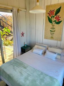 a bedroom with a bed and a window with a vase at Sand Wood Lofts in José Ignacio