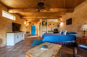 um quarto com uma cama azul e um tecto de madeira em Sirena Vineyard Resort em Paso Robles