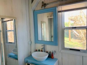 a bathroom with a sink and a mirror at Sand Wood Lofts in José Ignacio