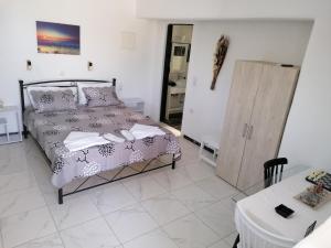 a bedroom with a bed and a table and a cabinet at Countryside Retreat 4 in Agios Arsenios