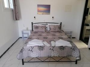 a bedroom with a bed with a black and white comforter at Countryside Retreat 4 in Agios Arsenios