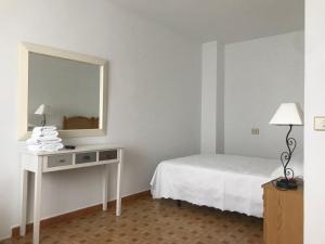 a white room with a bed and a mirror at Hostal Casa Enrique in Barres