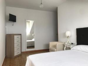 a bedroom with a bed and a chair and a mirror at Hostal Casa Enrique in Barres +5 photos