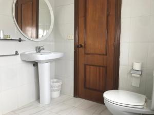 a bathroom with a toilet and a sink and a mirror at Hostal Casa Enrique in Barres