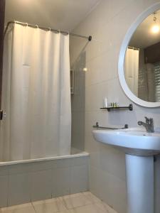 a bathroom with a shower and a sink and a mirror at Hostal Casa Enrique in Barres