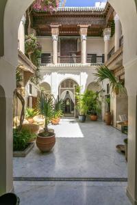 a courtyard with potted plants in a building at Riad Safar in Marrakesh
