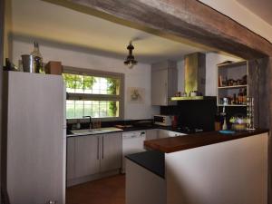 una cocina con armarios blancos y una ventana en Villa Montseny, en Santa Cristina d'Aro