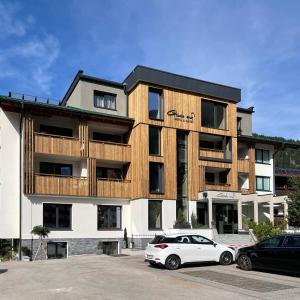 ein Gebäude mit einem weißen Auto, das davor geparkt ist in der Unterkunft Hotel & Suites Glück Auf in Mayrhofen