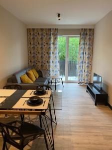 een woonkamer met een bank en een tafel bij Apartamenty Poproszę Nad Morze in Jastrzębia Góra