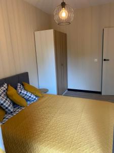 een slaapkamer met een bed met gele kussens en een kast bij Apartamenty Poproszę Nad Morze in Jastrzębia Góra