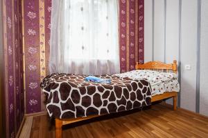 una cama con un edredón marrón y blanco frente a una ventana en Bori's Guesthouse, en Ushguli