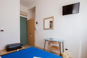 a room with a desk and a table and a mirror at Hotel Villa del Mare in Senigallia