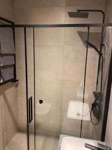 een badkamer met een glazen douche met wastafel bij Apartamenty Poproszę Nad Morze in Jastrzębia Góra