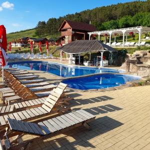 a large swimming pool with loungers and a house at La Hacienda in Cheţani