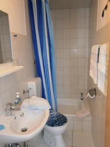 łazienka z toaletą, umywalką i wanną w obiekcie Haus Steinbach w mieście Kellenhusen