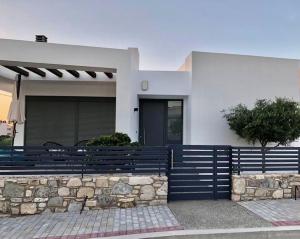 a house with a blue fence in front of it at Casa Lagada Kos Private Residence. in (( Kermetés ))