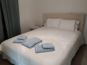 a white bed with three folded towels on it at Casa Lagada Kos Private Residence. in (( Kermetés ))