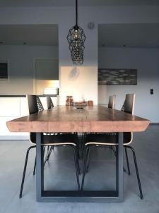 a wooden dining table with chairs and a chandelier at Casa Lagada Kos Private Residence. in (( Kermetés ))