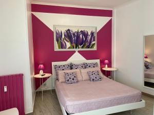a bedroom with a purple accent wall and a bed at Alloggio breve Anthea in Bari
