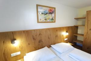 1 dormitorio con 1 cama y una foto en la pared en Gästehaus Scherl, en Pettneu am Arlberg