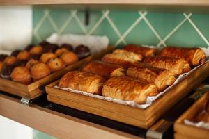 a bunch of pastries and other baked goods on a shelf at Seraphine Kensington Olympia in London