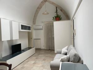 a living room with a couch and a tv at Casa Oberdan - private parking in Monopoli