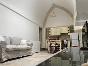 a living room with a couch and a kitchen at Casa Oberdan - private parking in Monopoli