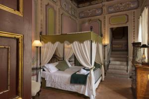 a bedroom with a canopy bed and a staircase at Castello Costaguti in Roccalvecce