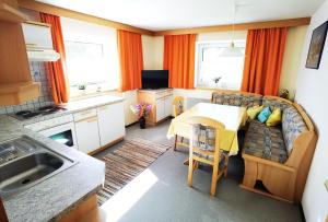 a kitchen and living room with a table and a couch at Gästehaus Scherl in Pettneu am Arlberg