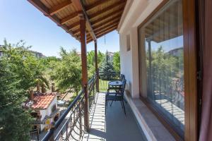 un balcon avec une table et des chaises dessus dans l'établissement Къща за гости Перуника, à Sapareva Banya