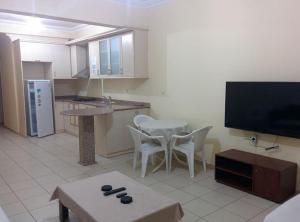 a kitchen with a tv and a table and chairs at Orange Grove Apart Hotel in Alanya