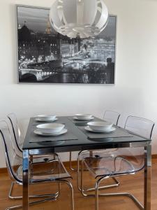 une table à manger avec des chaises et une photo sur le mur dans l'établissement PARKING, vistas al MAR y tres habitaciones, à La Corogne