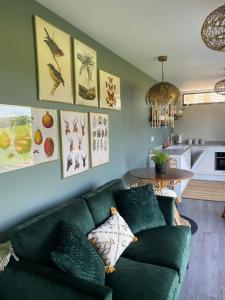 Hazy Hollow في Pilton: غرفة معيشة مع أريكة خضراء وطاولة