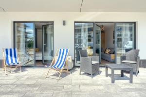two blue and white chairs and chairs on a patio at Navy Blue Dream - SPA - Basen - Parking in Dziwnów