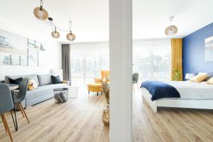 a bedroom with a bed and a living room at Navy Blue Dream - SPA - Basen - Parking in Dziwnów