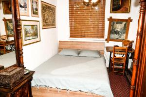 a bedroom with a bed and a table and a desk at Idilliska Latgaliešu lauku māja ar melno pirti in Aglona