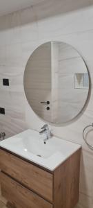 y baño con lavabo y espejo. en L&C BEACH HOME by ZORA Rezidential - PE PLAJA, en Mamaia Nord – Năvodari