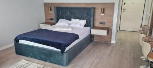 1 dormitorio con 1 cama grande y cabecero azul en L&C BEACH HOME by ZORA Rezidential - PE PLAJA, en Mamaia Nord – Năvodari