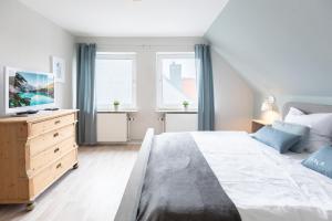 ein Schlafzimmer mit einem großen Bett und einem Fernseher in der Unterkunft Tante Tine in Husum