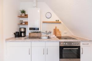 eine Küche mit weißen Schränken und einer Spüle in der Unterkunft Tante Tine in Husum