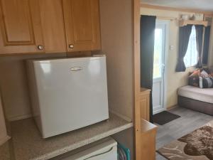 a kitchen with a white refrigerator in a room at 6 Berth The Chase Ingoldmells (Abi II) in Ingoldmells