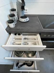 a kitchen with an open drawer with utensils at Moderne Wohnung nah am Cappenberger-See, 1-4 Gäste in Lünen