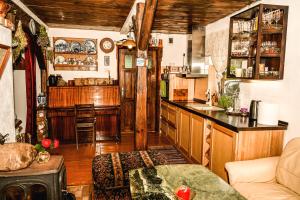 a living room with a kitchen and a counter top at Idilliska Latgaliešu lauku māja ar melno pirti in Aglona