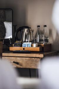 uma mesa com copos e uma chaleira de chá em The Bull Inn em Woolpit