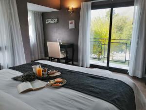 een hotelkamer met een dienblad met eten op een bed bij Atelier Hotel de Charme in Villa General Belgrano
